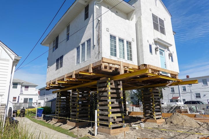 A team of professionals using specialized equipment to raise a house in Bondurant, preparing it for elevation and renovation